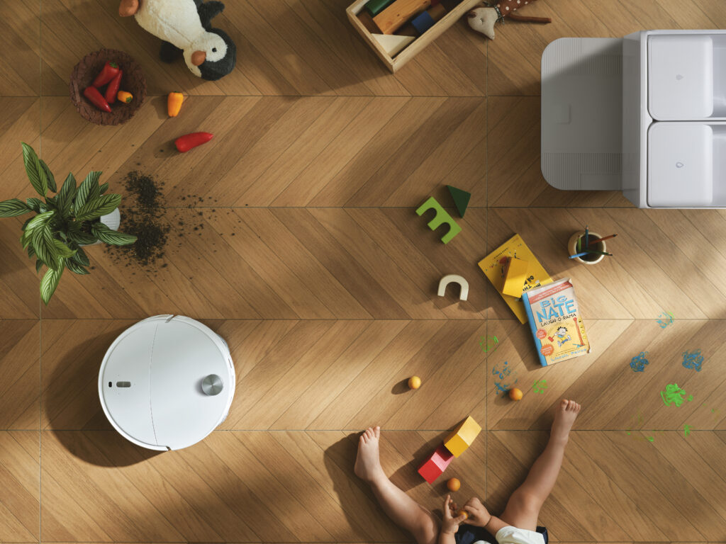 תמונה של ילד יושב על הרצפה לצד משחקים מפוזרים על הרצפה.